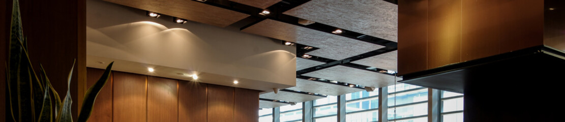 Modern restaurant ceiling and lighting design using spotlight and wooden material.