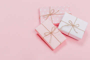 Gift box wrapped in pastel  paper with pink ribbon on pink surface. Top view  and  with copy space.