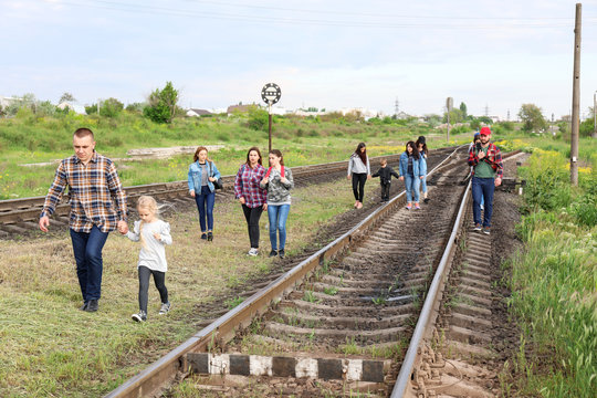 Group Of Illegal Migrants Walking Along Railway Tracks