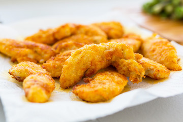 Fried chicken strips drying on the paper