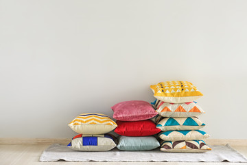 Soft pillows on floor near light wall