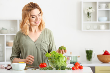 Obraz na płótnie Canvas Woman making healthy vegetable salad in kitchen