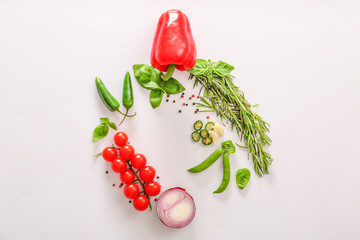 Fresh herbs with vegetables and spices on light background