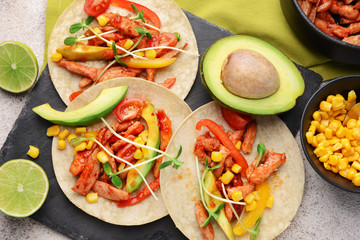 Slate plate with tasty fresh tacos on grey background