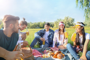 Happy friends on picnic in park