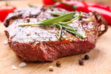 Tasty grilled meat on wooden board, closeup