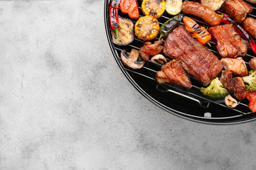 Grill with tasty cooked meat and vegetables on grey background