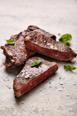 Tasty grilled meat on grey background
