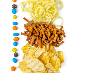 Assortment of Unhealthy Snacks: chips, onion rings, crackers top view, flat lay. Unhealthy eating concept.