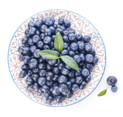 Plate with ripe blueberry on white background