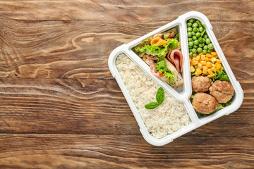School lunch box with tasty food on wooden table
