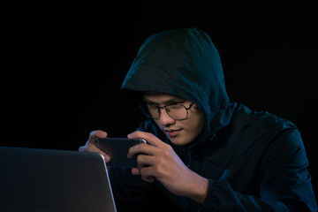 Hacker using a smartphone. Very dark nocturnal environment