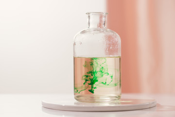 Green color dropping into a bottle of water