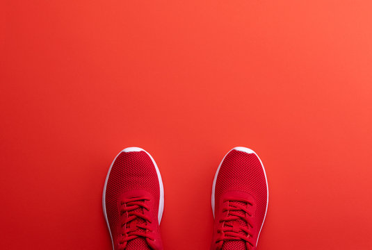 A studio shot of pair of running shoes on red background. Flat lay.