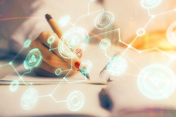 Social network theme hologram over hands taking notes background. Concept of global international people connect. Double exposure