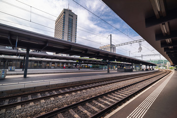 Fototapeta na wymiar Perspective View of Railway Platform and Rail Track, Passengers and Exchange Station of Swiss Transit Train, Europe Public Rail Pass, Travel Switzerland
