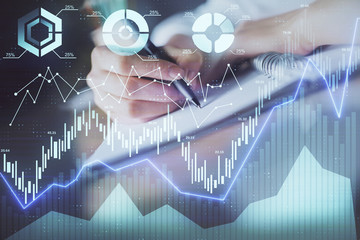 Financial forex graph displayed on hands taking notes background. Concept of research. Double...