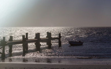 Lonely fishing boat and sea pier in dark ocean, sea.