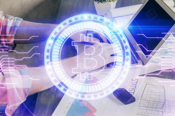 Crypto currency theme hologram with businessman working on computer on background. Concept of...