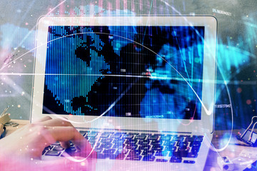 Double exposure of businessman working on laptop on background. International business hologram in front. Concept of success.