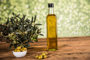 Olive oil, olive tree and green olives, bottles of olive oil.