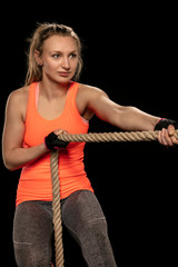athletic girl exercising with a thick rope