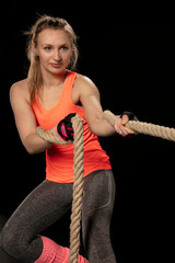 athletic girl exercising with a thick rope