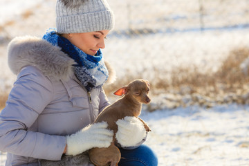 Woman playing with dog during winter