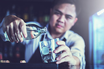 Handsome bartender serving cocktail