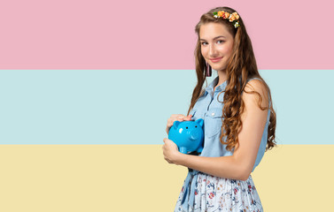 Beautiful young woman with piggy bank isolated