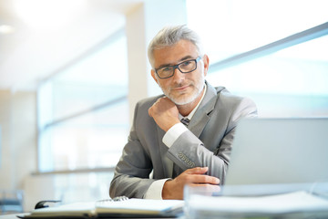 Portrait of mature businessman sitting in office looking at camera