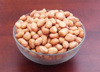 Peanuts in bowl on brown table
