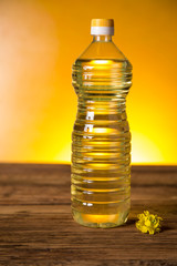 Rapeseed flowers and rapeseed oil in a bottle on the table