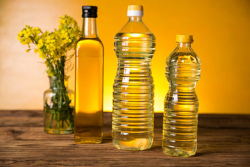 Rapeseed flowers and rapeseed oil in a bottle on the table