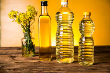 Rapeseed flowers and rapeseed oil in a bottle on the table