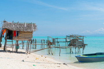 Thatched structures over waters edge on tropical island.