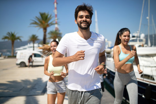 Running, friends, sport, exercising and healthy lifestyle concept. Happy people jogging outdoor. © NDABCREATIVITY