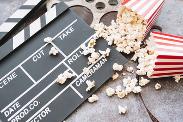 Cinema clapperboard with popcorn box