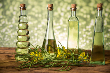 Seeds and rape flowers in bottles and carafes with rapeseed oil