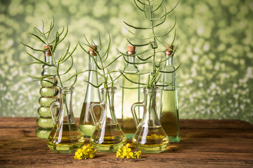 Seeds and rape flowers in bottles and carafes with rapeseed oil