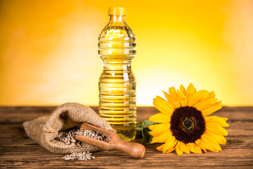 Sunflower oil in a bottle and sunflower flowers and sunflower seeds in a sack