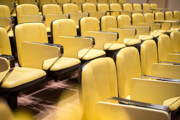Naklejka premium Rząd żółtych miejsc w audytorium przygotowuje do nauki, konferencji lub pokazu