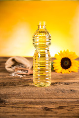 Sunflower oil in a bottle and sunflower flowers and sunflower seeds in a sack