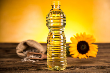 Sunflower oil in a bottle and sunflower flowers and sunflower seeds in a sack