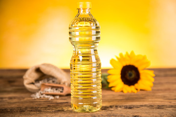 Sunflower oil in a bottle and sunflower flowers and sunflower seeds in a sack