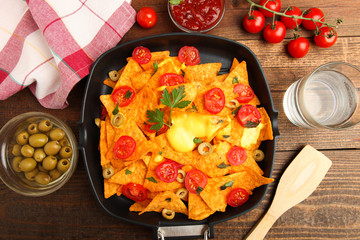 Corn chips nachos with cherry and olives in pa