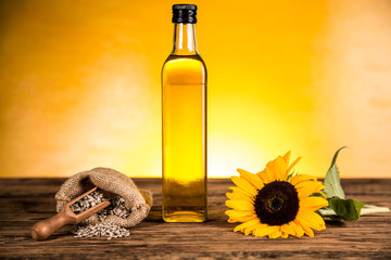 Sunflower oil in a bottle and sunflower flowers and sunflower seeds in a sack