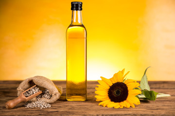 Sunflower oil in a bottle and sunflower flowers and sunflower seeds in a sack