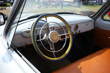 The large retro steering wheel and the interior of the Soviet car convertible.
