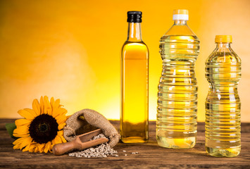 Sunflower oil in a bottle and sunflower flowers and sunflower seeds in a sack